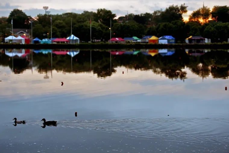 A pair of ducks pass the tents of the  athlete's village, on the Cooper River in Camden County at sunset in May 2018. The Senate has passed a bill that would mean later sunsets year-round.
