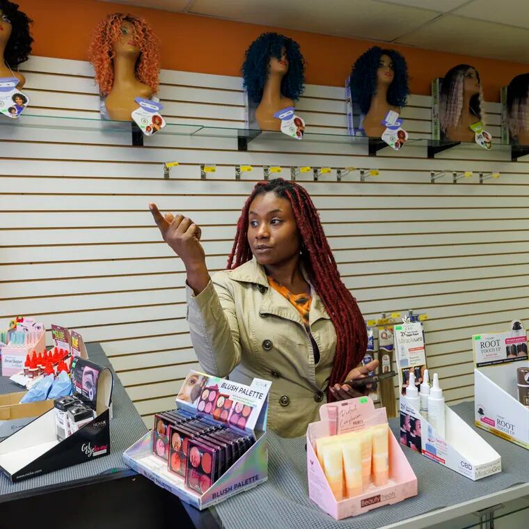Claudia Silmeas, owner of Nat’s Beauty Supply along Frankford Avenue and Knorr Street was hit by mass theft of merchandise at her small business beauty supply store overnight on Thursday. Behind her is the area targeted by thieves, her most expensive hair.