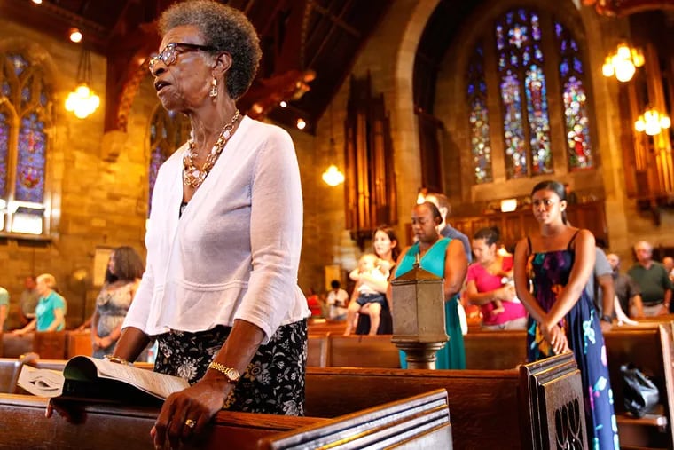 Elizabeth Walker, a member of Holy Cross for 40 years, repeats prayers at Mass. An estimated 20,000 black Catholics are in the archdiocese. (Michael Bryant/Staff Photographer)