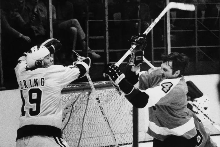 Flyers defenseman Barry Ashbee raises his stick to swing at the Los Angeles Kings' Butch Goring on Nov. 15, 1973. Ashbee held back and there was no penalty.