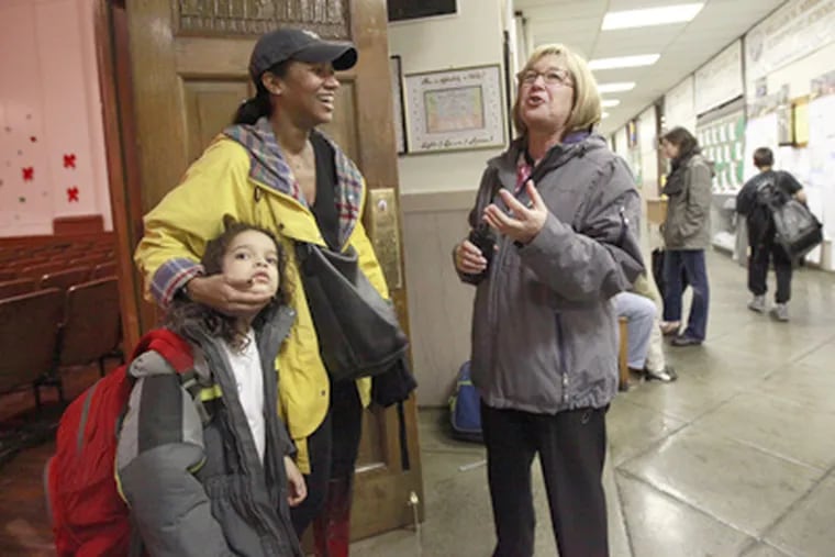 Principal Cindy Farlino (right) and Cindy Clark, with her son Caleb, talk about the giving spirit that blunted some cuts. (David Swanson / Staff Photographer)