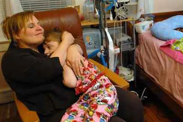 Melissa Perry rocks with her daughter, Sara Ann Kronot, at bedtime. Sara has severe cerebral palsy. ( April Saul / Staff Photographer )