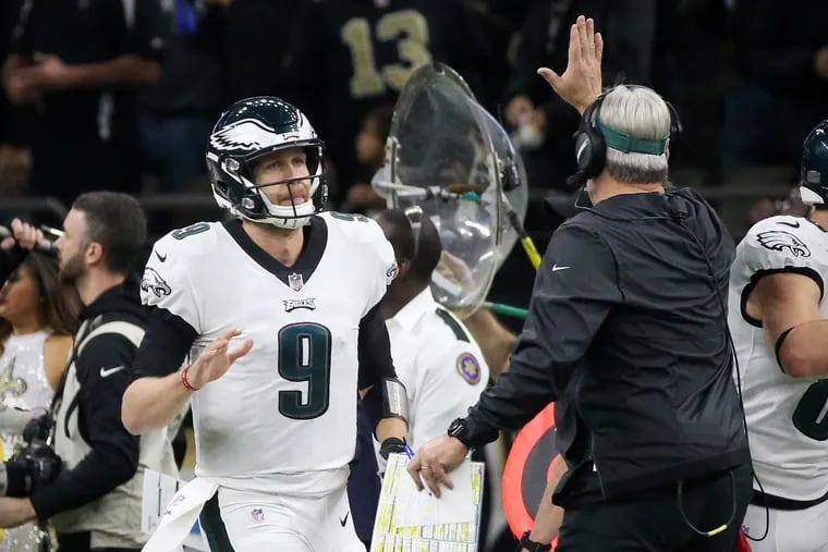 Eagles quarterback Nick Foles (9) high-fives head coach Doug Pederson after throwing for a touchdown in the first quarter of their divisional round playoff game against the New Orleans Saints at the Mercedes-Benz Superdome in New Orleans on Sunday, Jan. 13, 2019. The Eagles lost 20-14, ending their season.