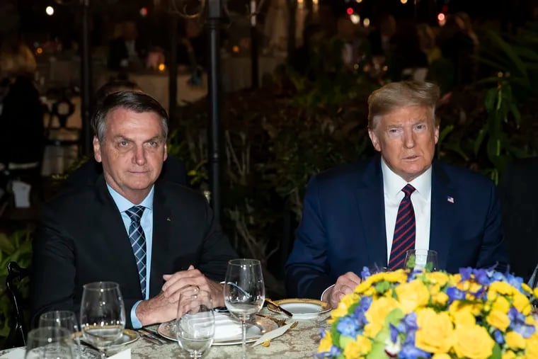 President Donald Trump (right) seated with Brazilian President Jair Bolsonaro (left) for a dinner event at Trump's Mar-a-Lago club in Palm Beach, Fla. this past March.