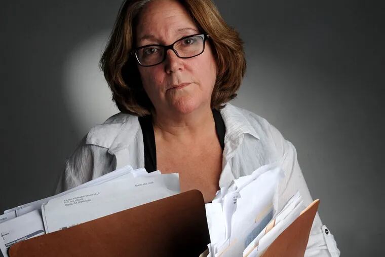 Christine Cortese holds packed folders full of correspondence from the IRS after her and her husband's identity were compromised, not once but twice, due to insufficient IRS security. (CLEM MURRAY
/ Staff Photographer)