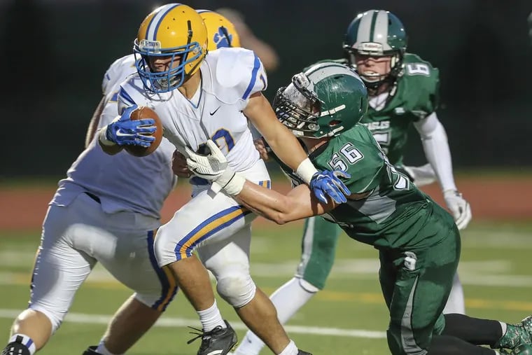 Downingtown East’s Garvey Jonassaint (left) drags Bishop Shanahan’s Mike Robinson on a scoring run in the first quarter.