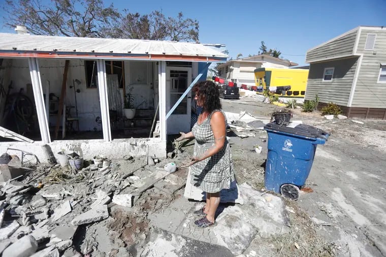 Temple Condon attempts cleanup of what's left of her mobile home where it sustained significant damage caused by Hurricane Ian that ravaged Fort Myers, Fla.