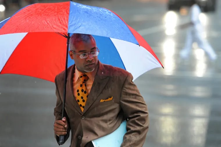 Damon K. Roberts ran through the rain at 15th and Market Streets on Thursday. A drought watch, called for Philadelphia and much of the rest of the state after the summer’s dry start and before August’s drenching rains, remains in effect. (Clem Murray / Staff Photographer)