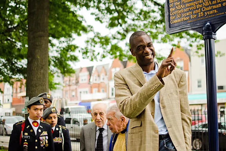 Hall of Famer Dikembe Mutombo and an honor guard from South Philadelphia HS attend the dedication of the historical plaque honoring Eddie Gottlieb, the basketball icon and former coach and manager of the Philadelphia Warriors. ( VIVIANA PERNOT / Staff Photographer )