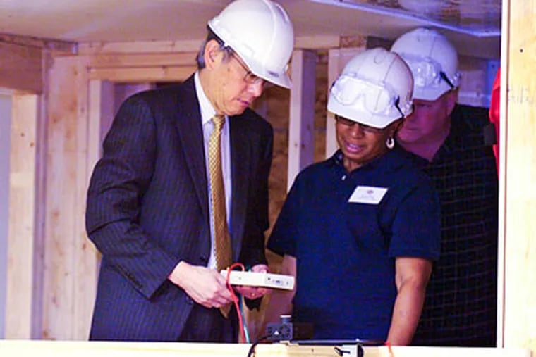 Secretary of Energy Steven Chu gets instructions on testing a home's energy efficiency by Dawn Moody a trainer at the Green Jobs Training Center in North Philadelphia during his tour of the facility. (Ron Tarver / Staff Photographer)