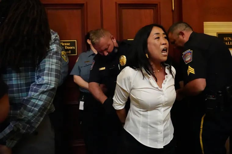 Philadelphia City Councilmember Helen Gym and activists with the interfaith group POWER are handcuffed after they blocked the Pennsylvania State Senate chamber doors and refused to move during a protest for more public school funding in the state budget on Wednesday in Harrisburg.