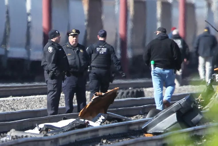 Debris from the collision of the Amtrak passenger train and the backhoe are strewn amid the rails as
Amtrak police investigate April 3, 2016.