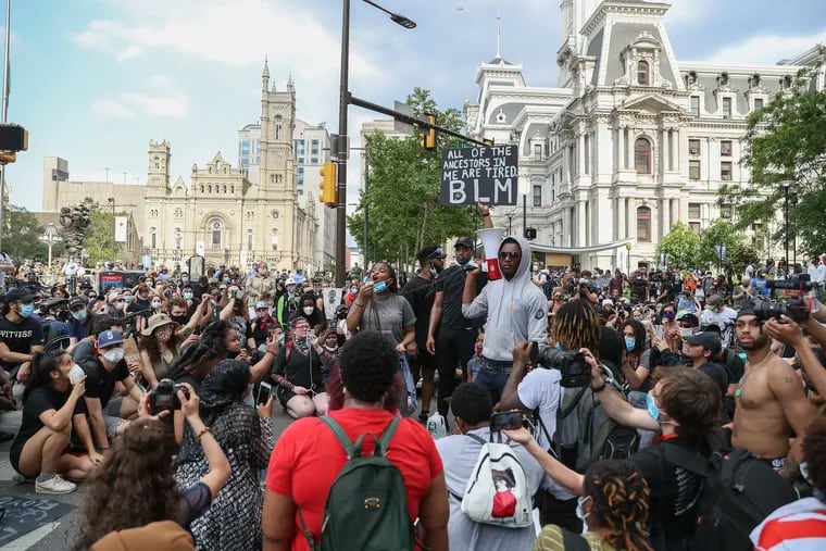 Hundreds of protesters take a knee and listen to speeches outside of City Hall in Philadelphia on Wednesday. It was the fifth day of protests against the killing of George Floyd at the hands of Minneapolis police.