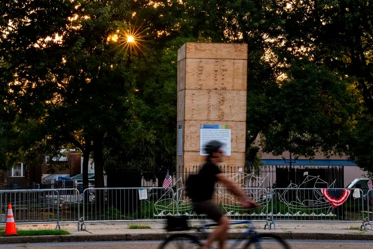 The statue of Christopher Columbus remains encased in a wooden box on Marconi Plaza Aug. 12, 2020, as the sun sets on the day the Philadelphia Art Commission voted to remove it and store it while the city deliberates on a new permanent home for the controversial monument.