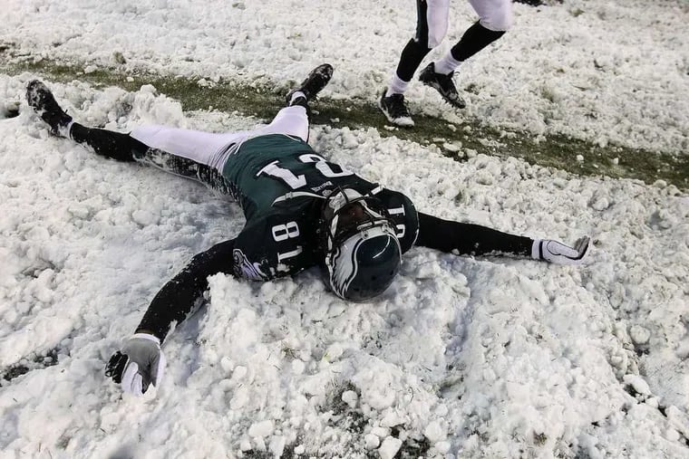 DAVID MAIALETTI / STAFF PHOTOGRAPHER Jason Avant is still a kid at heart, making snow angels after the Eagles' big victory over the Lions.