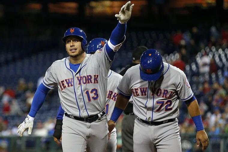New York Mets’ Asdrubal Cabrera, left, reacts to his three-run home run with Norichika Aoki, center, and Phillip Evans, right, during the 11th inning of a baseball game against the Philadelphia Phillies, Saturday, Sept. 30, 2017, in Philadelphia. The Mets won 7-4 in 11 innings.