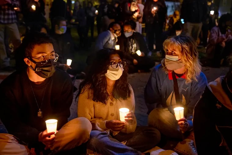 Andre Pak (from left), 20; Sruthy Mammen, 16; and Arden Allman, 17; with the "The New Normal" podcast, attend a vigil in Mifflin Square Park last month for Christian Hall, a 19-year-old said to be experiencing a mental health crisis who was shot by Pennsylvania State Police.