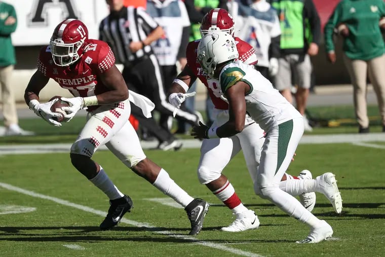 Temple defensive end Arnold Ebiketie (left) scoops up the ball after a fumble by USF quarterback Jordan McCloud (right) and runs it in for a touchdown in the fourth quarter on Saturday.

.