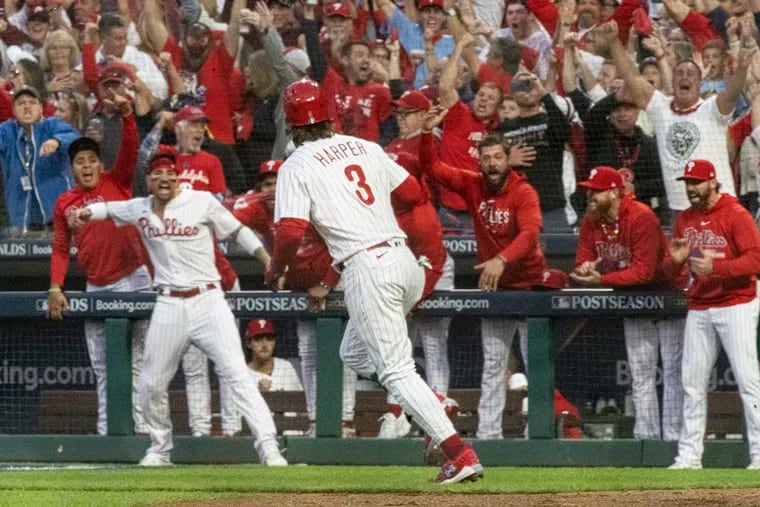 The Phillies' Bryce Harper runs the bases after a three-run homer in the third inning as his teammates celebrate.