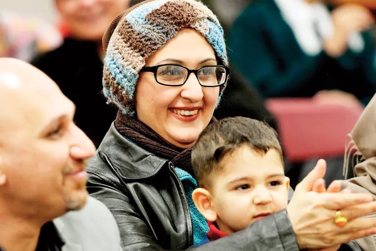 Rawnak Saaeed, originally from Iraq, listens, joined by husband Firas Alhelli and 3-year-old son Sam Alhelli. The diocese’s refugee settlement office helps find housing and employment.