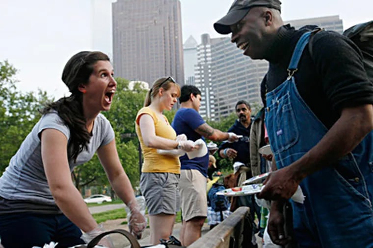 Rachel Koppenhaver talks while serving chicken pesto pasta on the Benjamin Franklin Parkway near Family Court. She is part of an outreach group from Liberti Church Fairmount. MICHAEL S. WIRTZ / Staff Photographer