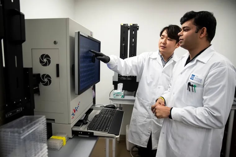 Daniel Park, a Penn graduate student, and Faraz Zaidi, a Wistar Institute project manager, use an ImmunoSpot machine to test the immune response of a vaccine for the new coronavirus.