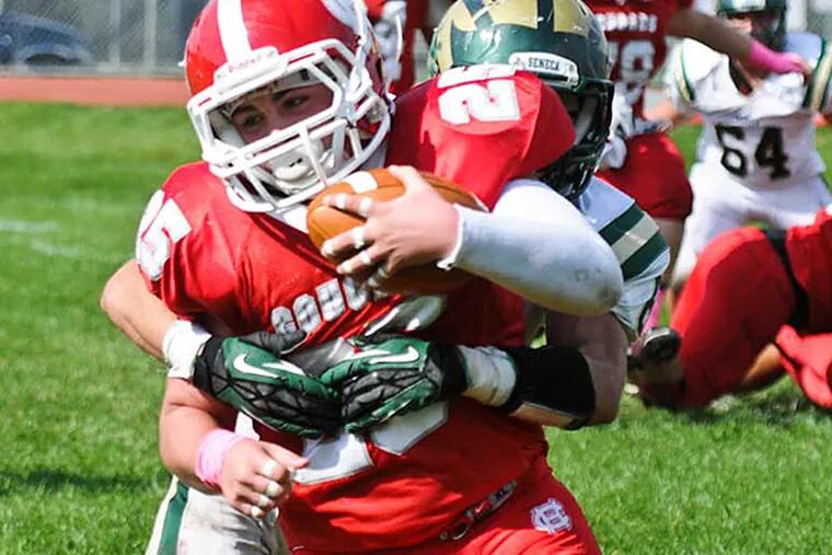 Cherry Hill East running back Mario Paglione carries as Seneca's Sam Pawlikowski tries for a tackle.  (Ron Tarver/Staff Photographer)