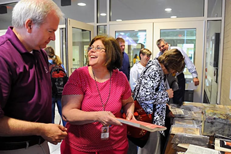Lower Merion high school secretary Darlene Mandranio, class of 1966, laughs after showing teacher Mike Stettner her photo from the 1965 yearbook, found in the time capsule.  (Clem Murray / Staff Photographer )