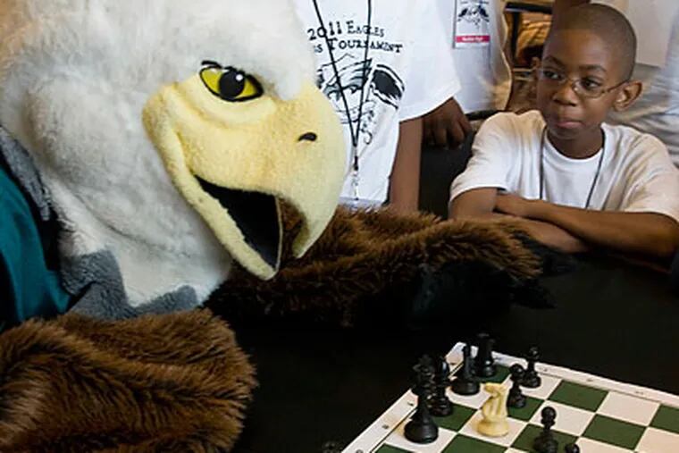 Swoop, the Eagles' mascot, plays chess with a student during an Eagles Youth Partnership event. (Photo courtesy of the Eagles)