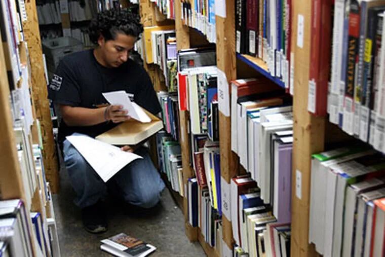 Jose Centeno, 19, of Hyattsville, Md., fills orders at Bookholders.com of College Park, Md., which sells used textbooks. (Susan Biddle / Washington Post)