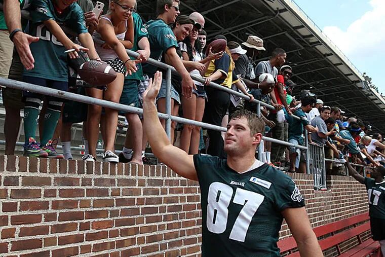 Brent Celek high-fives fans after practice at Franklin Field. (David Maialetti/Staff Photographer)