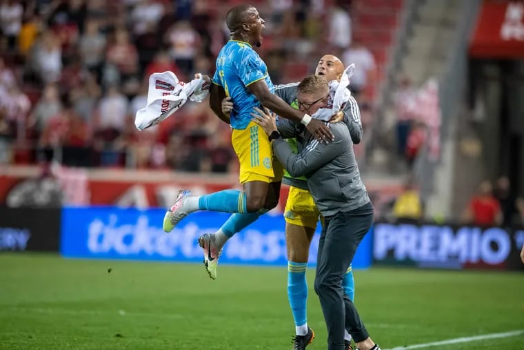 Sergio Santos (left) leaps into the arms of Jim Curtin (front right) and Aurélien Collin after scoring the late tying goal for the Union against the Red Bulls.