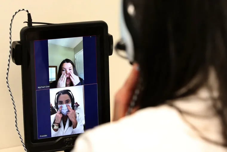 Lisa Ravindra conducts a remote monitoring telehealth visit with patient Jenny Thomas, top of screen, at Rush River North in Chicago, on Oct. 5.