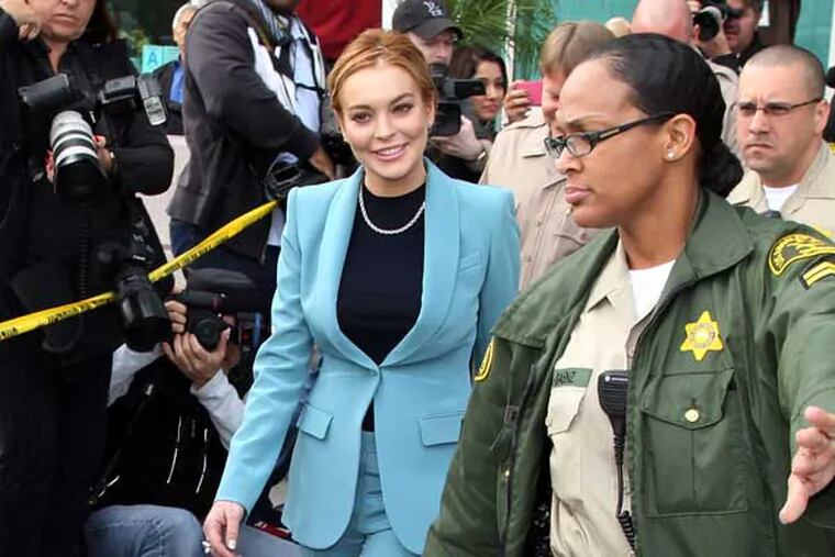 Lindsay Lohan leaves after a progress report on her probation for heft charges at Los Angeles Superior Court Thursday, March 29, 2012. A judge ended Lindsay Lohan's supervised probation on Thursday, giving the actress her freedom after nearly two years of constant court hearings and threats of jail. Lohan thanked Superior Court Judge Stephanie Sautner for her patience and let out a sigh of relief as she exited the courtroom after the brief hearing. (AP Photo/Reed Saxon)
