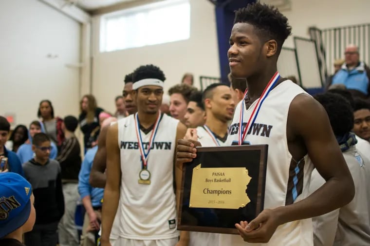 Westtown's Anthony Ochefu holds the PAISAA championship plaque after defeating Germantown 73-65 on Saturday, Feb. 27, 2016.