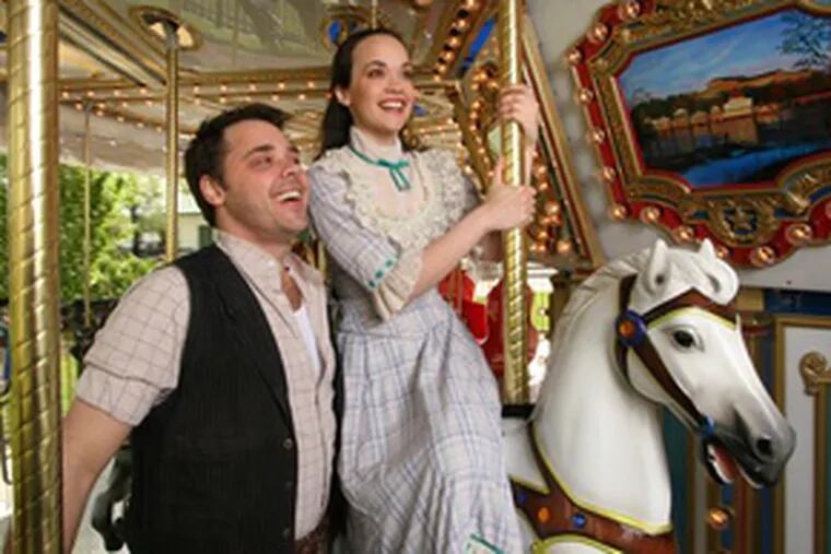 Jeff Coon stars as Billy Bigelow and Julie Hanson is Julie Jordan in &quot;Carousel,&quot; at the Walnut Street Theatre through July 15. Here, they pay a visit to Philadelphia&#0039;s classic carousel at Franklin Park.