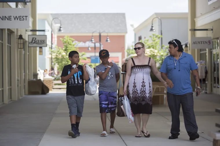 Angel Lazaro (left), 10, and his brother, Carlos (second from left), 12, walk through Gloucester Premium Outlets with Shawna Williams (second from right) and Juan Lazaro (right) Friday, June 30, 2017. ( MARGO REED / Staff Photographer )