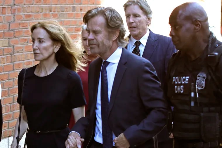 Felicity Huffman arrives at federal court with her husband William H. Macy and her brother Moore Huffman Jr., back, for sentencing in a nationwide college admissions bribery scandal.