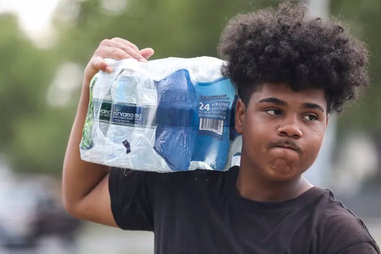 Isaiah Cruz, 16, selling water on the corner of Marlton Pike and Baird Boulevard in Camden on Monday.