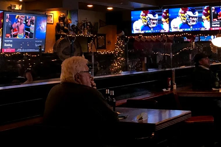 Joe Leonard of Somers Point, N.J. watches the Eagles game at P.J. WhelihanÕs Pub & Restaurant in Westmont, N.J. one of the few Eagles fans out on a rainy night Jan, 3, 2021. He was visiting his family, including his stepson, Michael Yost, who is a bartender there
 (limited indoor seating is permitted  in restaurants in New Jersey)