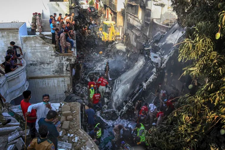 Volunteers look for survivors of a plane that crashed in a residential area of Karachi, Pakistan.