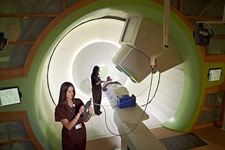 Therapists Courtney Thomas (left) and Kristen Burnett preparing for a proton beam treatment at the University of Pennsylvania&rsquo;s Roberts Proton Therapy Center.  Lien/Nibauer Photo Inc.