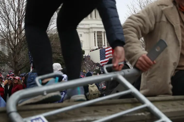 An American flag can be seen on the side of the U.S. Capitol building as Trump supporters climbed over the barricades in Washington on Wednesday, Jan. 6.