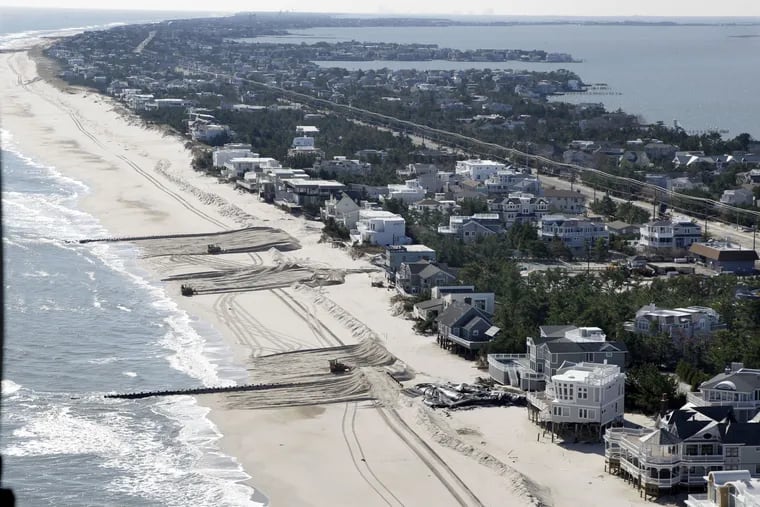 In this aerial photograph, heavy equipment continues working to restore a barrier dune along the Atlantic Ocean in Loveladies on Long Beach Island, N.J., Friday, Nov. 9, 2012, after the region was pounded by Superstorm Sandy.