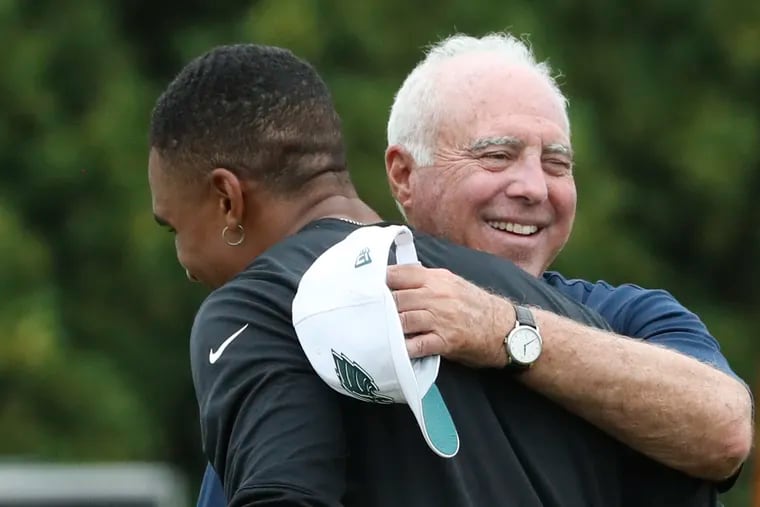 Eagles quarterback Jalen Hurts and team owner Jeffrey Lurie greet each other after training camp at the NovaCare Complex in South Philadelphia on Wednesday, Aug. 4, 2021.