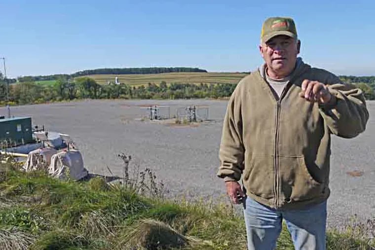 Robert Marquardt, a beef cattle farmer outside of Hughesville, Pa., said there has been no lasting damage from the spill of Marcellus Shale wastewater that happened at the well site on his farm in 2010. He stands on the edge of the gravel well site. The spill happened on the edge of the well pad in the distance, and more than 50,000 gallons of wastewater went over the side. Photo by Andy Maykuth