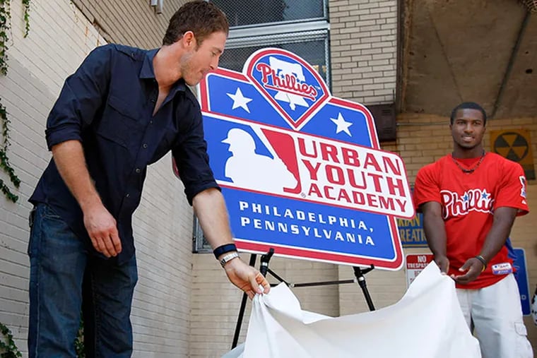 The Phillies' Chase Utley (left) and Demetrius Jennings in 2010, unveiling a sign for the academy. (DAVID MAIALETTI / STAFF PHOTOGRAPHER)
