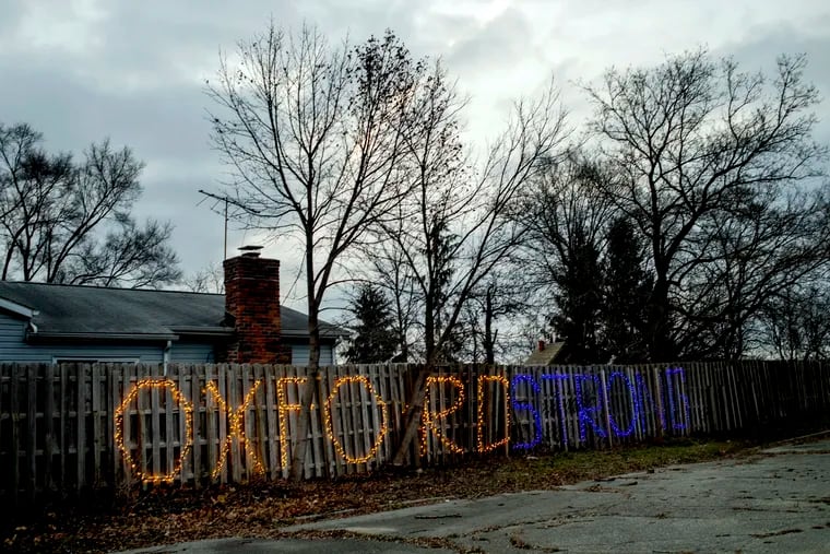 The message "Oxford Strong" lights up a fence along M-24 in Oxford High School's colors on Tuesday, Dec. 7, 2021 in Oxford. Less than two years later, as Michigan State University students evacuated campus following a shooting, one student was seen in an "Oxford Strong" sweatshirt. The schools are about 90 minutes away. (Jake May | MLive.com)