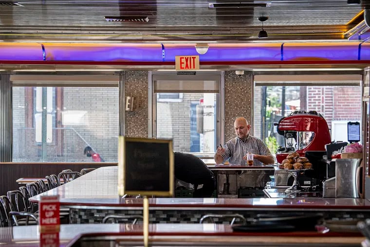 An unidentified man eats at the counter at Melrose Diner in Philadelphia on Tuesday, the first day that indoor dining was permitted to resume in the city.