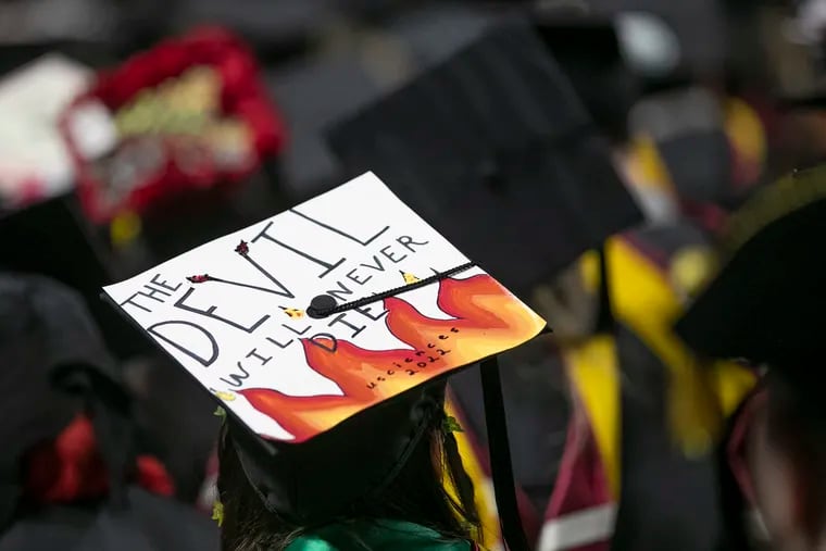 A student wears a graduation cap in reference to the USciences mascot, Drake the Devil, and the upcoming merger of USciences and St. Joseph’s during the University of the Sciences final commencement ceremony at the Liacouras Center in Philadelphia on Wednesday, May 25, 2022. The University of the Sciences merged with and into St. Joseph's University on June 1.